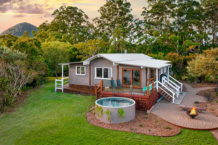 Drone footage of The Lodge, the pool, the deck and surrounding trees and mountains.
