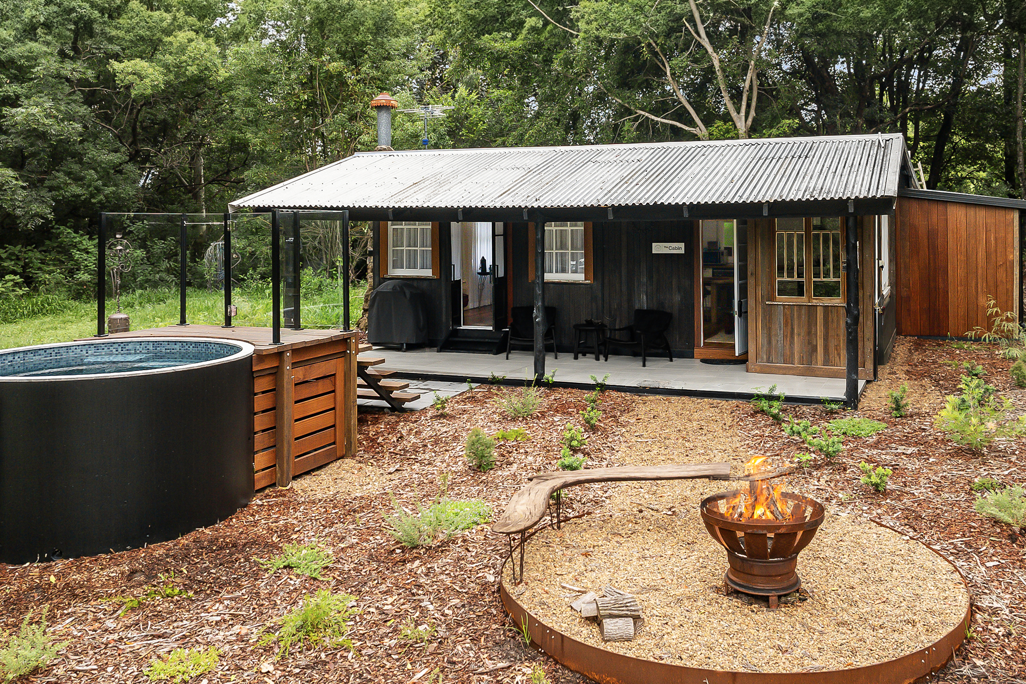 A cozy firepit in the front yard of the Noosa Pomona Retreat, perfect for gathering under the stars with a view of nature.